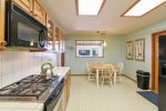 The kitchen offers access to the garage, dining room, and has a peak window into the den